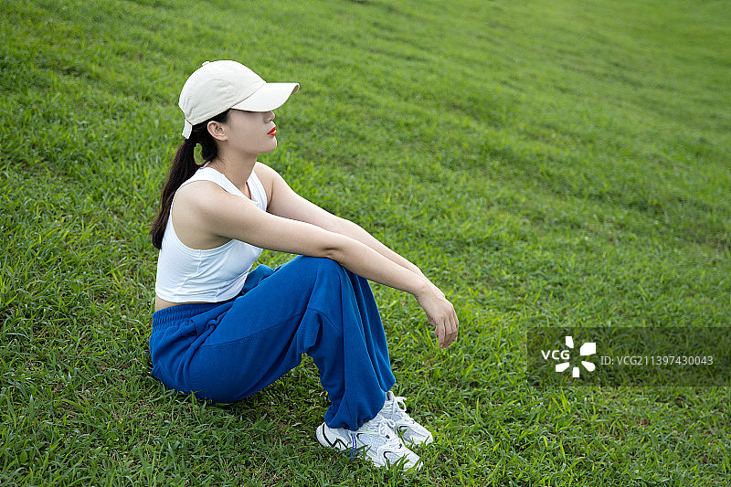 在草地上坐着的运动系女生图片素材