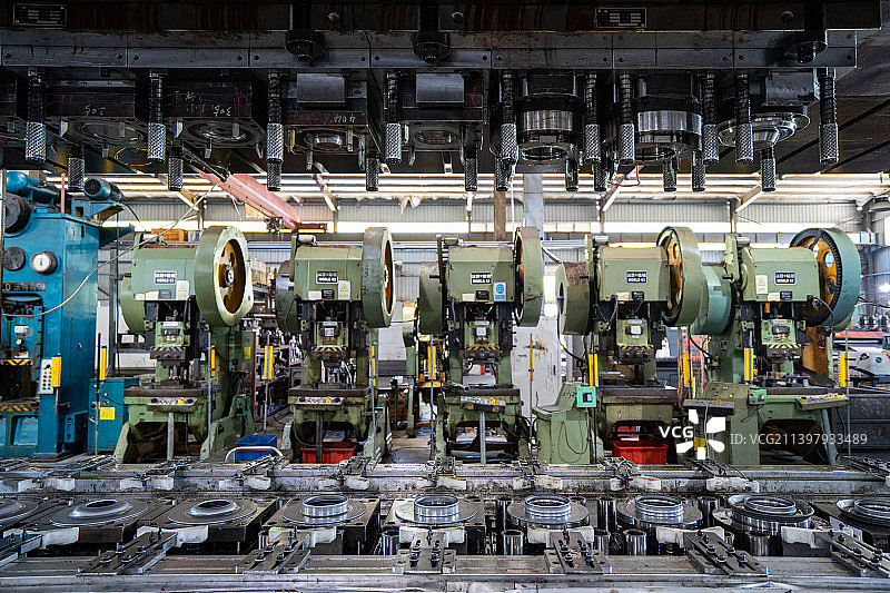 工厂车间内复杂的液压冲压机器特写图片素材