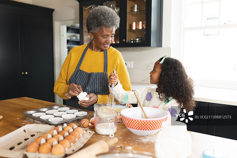 快乐的非洲裔美国祖母和孙女在厨房烘焙的画面图片素材