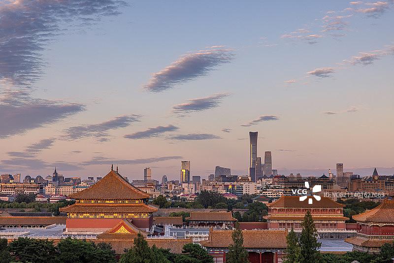 傍晚日落时分航拍视角俯瞰故宫宫殿全景和北京城市天际线图片素材