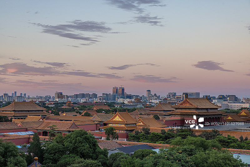 傍晚日落时分航拍视角俯瞰故宫宫殿全景和北京城市天际线图片素材