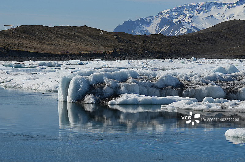 一座巨大的冰山的侧视图，上面有很多沉积物图片素材