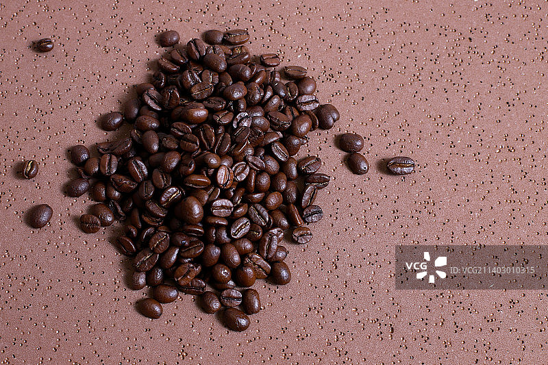 咖啡豆在棕色的桌子上烤图片素材