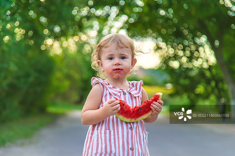 小女孩夏天吃西瓜选择性聚焦图片素材