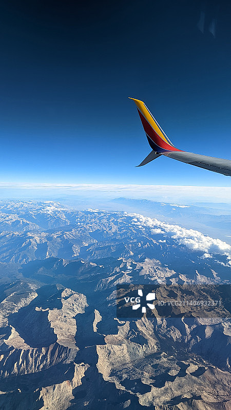 裁剪的图像飞机飞过雪山对蓝天图片素材
