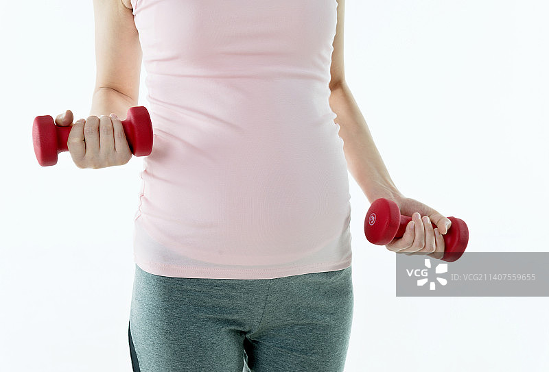 怀孕的女人手举着哑铃锻炼图片素材