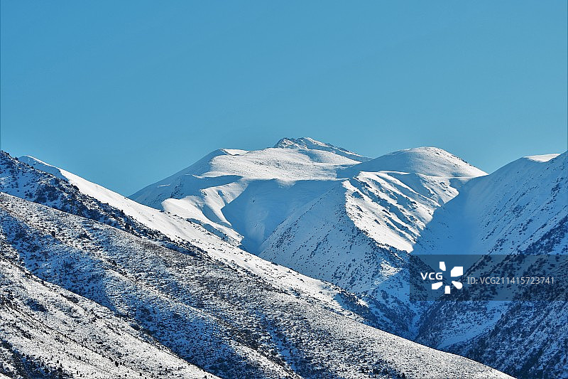白雪皑皑的山峦映衬着清澈的蓝天图片素材