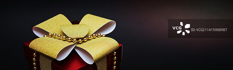 红色礼盒，金色蝴蝶结和黑色背景珠子，阿拉德，罗马尼亚图片素材