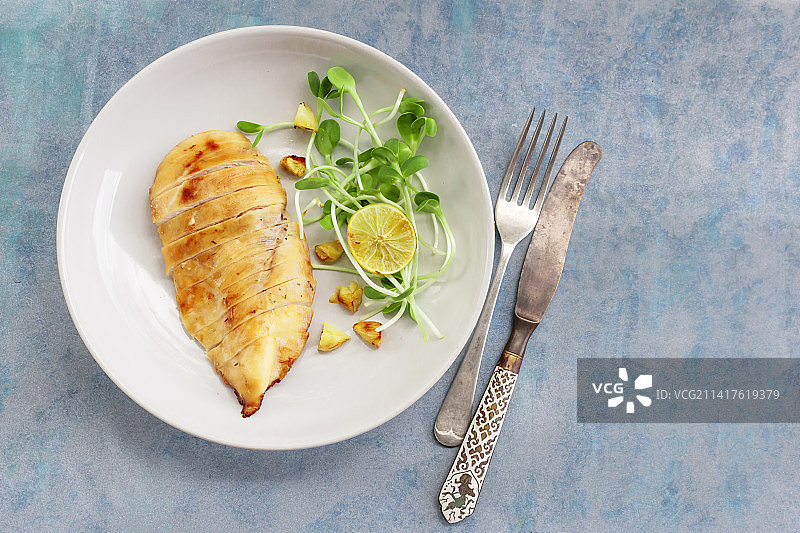 健康食品烤鸡大蒜柠檬盘子上的蓝色木材背景，泰国图片素材