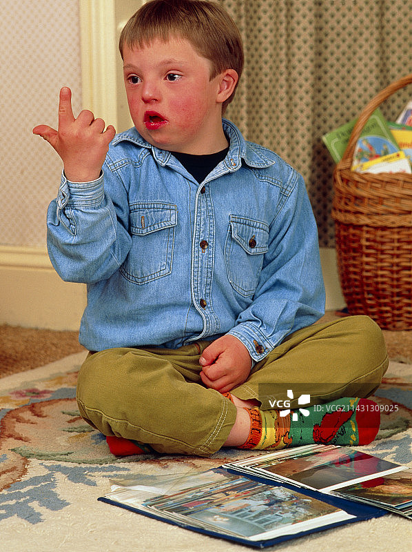 患有唐氏综合症的7岁男孩:手语图片素材