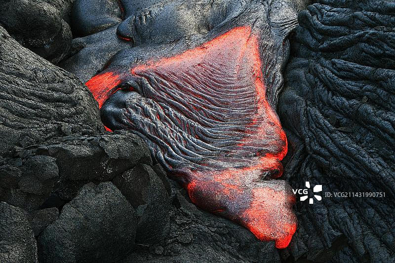 熔融的pahoehoe型熔岩从东部裂谷带的裂缝流向大海，基拉韦厄盾状火山的熔岩田，夏威夷火山国家公园，卡拉帕纳，夏威夷，北美图片素材