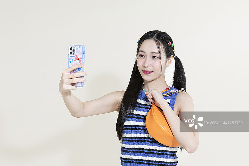 韩国亚洲可爱女人拿着包和智能手机的复古y2k粉红色复古概念照片图片素材