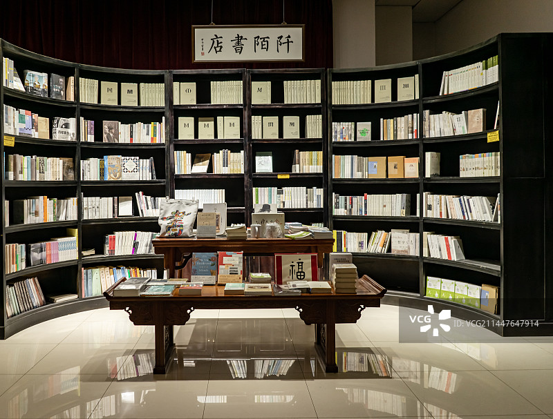 中国图书馆拍摄主题，弯曲的书柜书架子上陈列着各种各样的书籍，室内无人图像图片素材