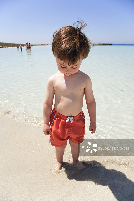 男孩用脚测试海水温度图片素材