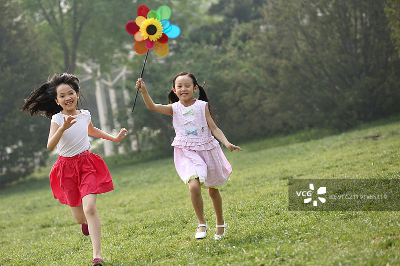 两个小女孩在草地上奔跑图片素材