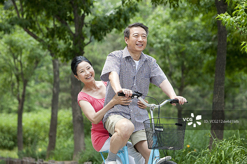 老年夫妻公园内骑自行车图片素材