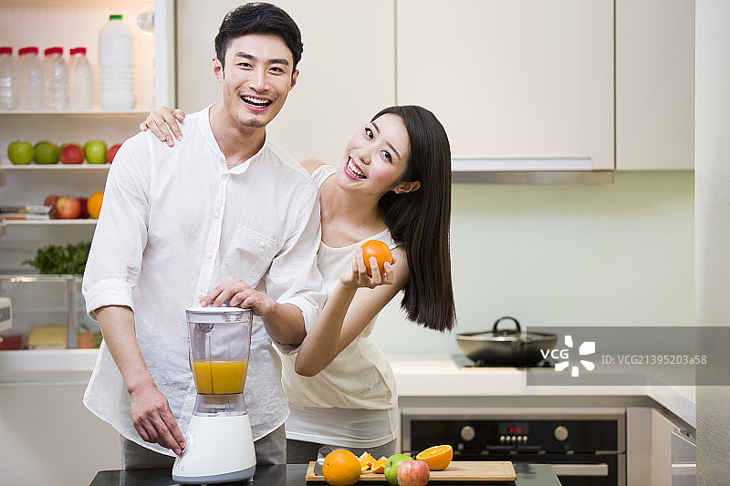 年轻夫妇在厨房使用榨汁机图片素材