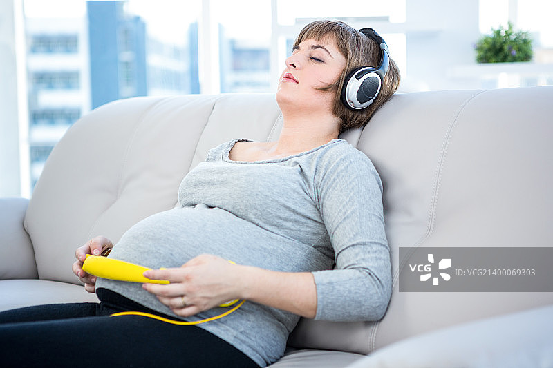 孕妇在家里闭着眼睛听音乐图片素材