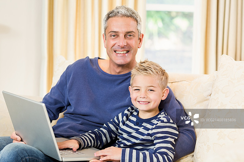 父亲和儿子使用笔记本电脑在t图片素材