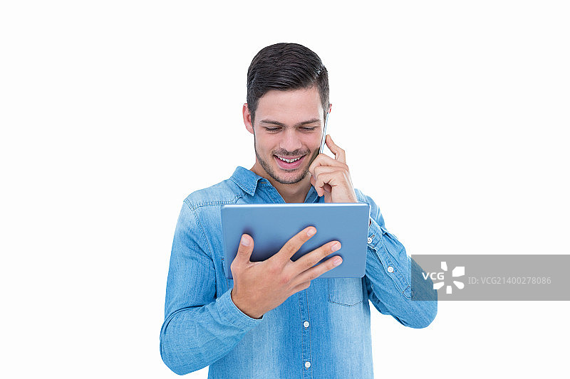 帅气的潮人在手机上拿着平板电脑在白色的背景图片素材