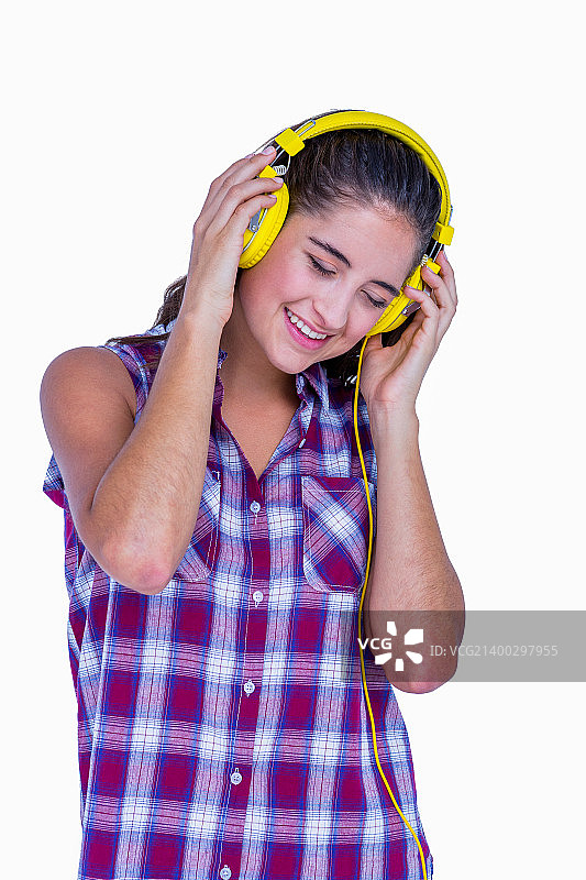 漂亮的黑发女人用耳机听白色背景音乐图片素材