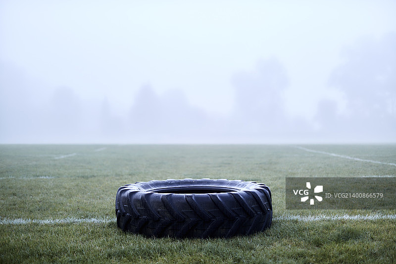 雾蒙蒙的足球场上的橡胶轮胎图片素材