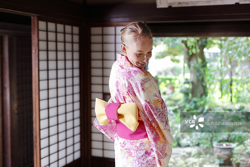 在传统的日本房子里穿着浴巾的白人妇女图片素材