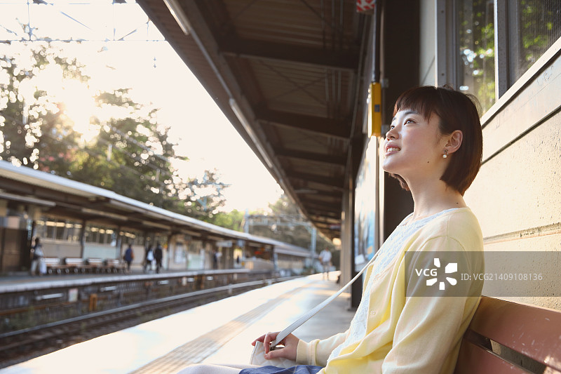 一个年轻的日本女人在火车站图片素材