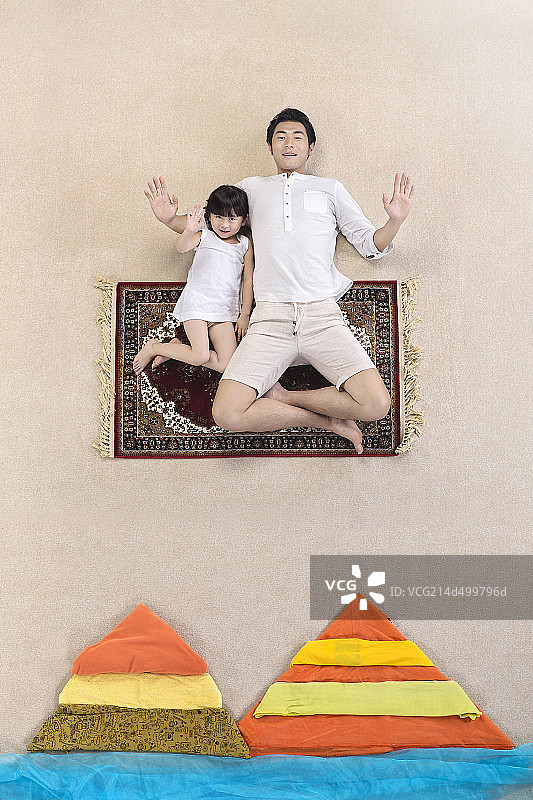 坐在飞毯上的父女二人图片素材