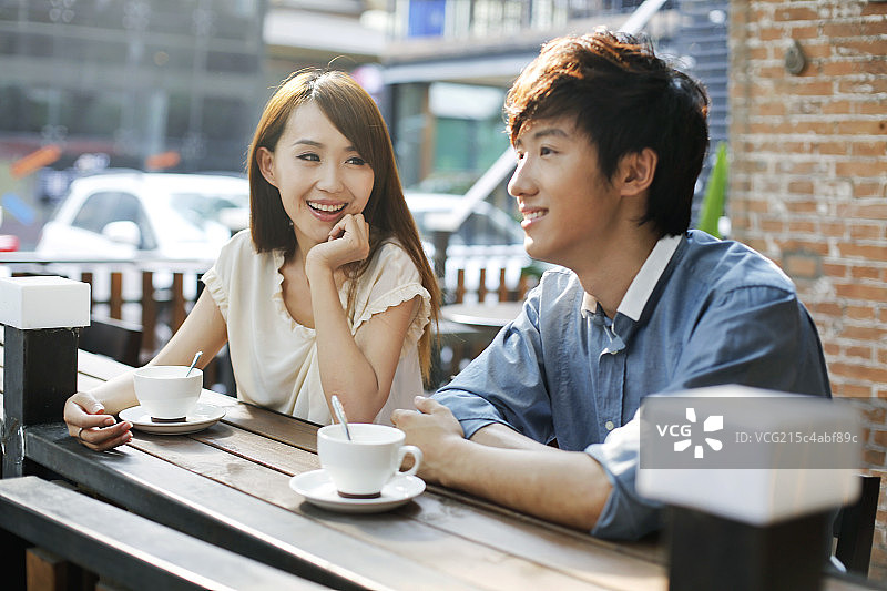 青年情侣在露天咖啡厅约会图片素材