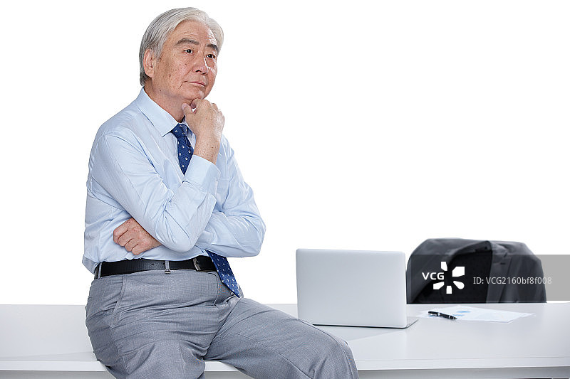 一个成功的老年男人坐在办公室思考图片素材