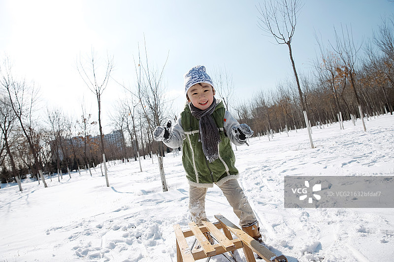 小男孩在雪地上玩耍图片素材