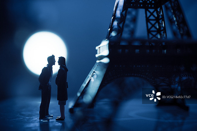 月光下铁塔旁对视的情侣图片素材