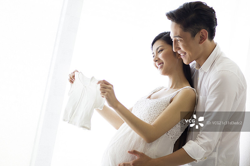 年轻夫妇和婴儿衣服图片素材