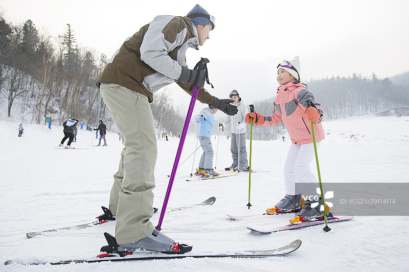 年轻的父母教子女滑雪图片素材