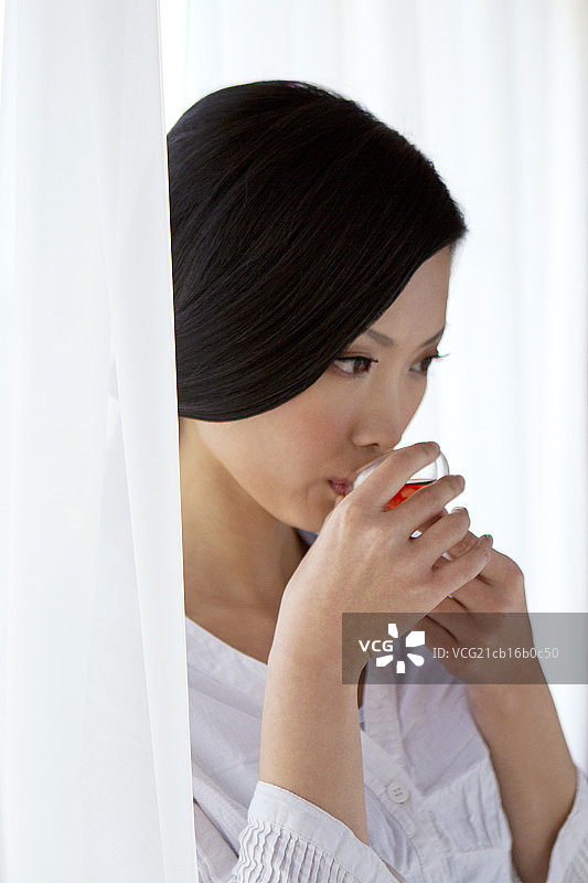 东方年轻女性喝茶特写图片素材