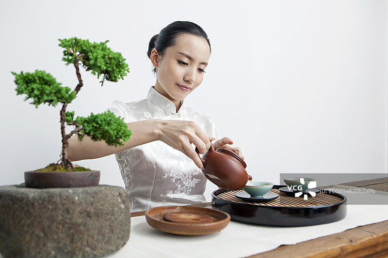 一个东方女性茶艺师做茶艺图片素材