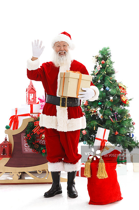 一个圣诞老人正在抱着圣诞礼物图片素材