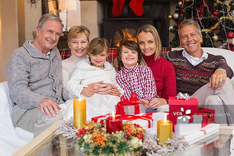 多代同堂的家庭在圣诞节期间在客厅对着镜头微笑图片素材
