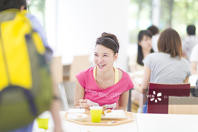 微笑的大学生在自助餐厅吃午饭图片素材