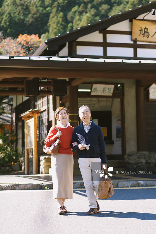 秋天，一对日本老夫妇在传统公园里放松图片素材