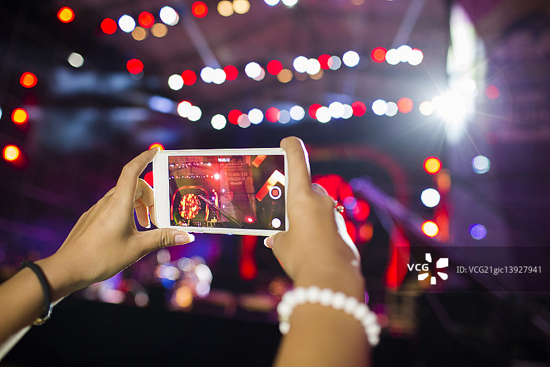 年轻女子在音乐节上用手机拍照图片素材