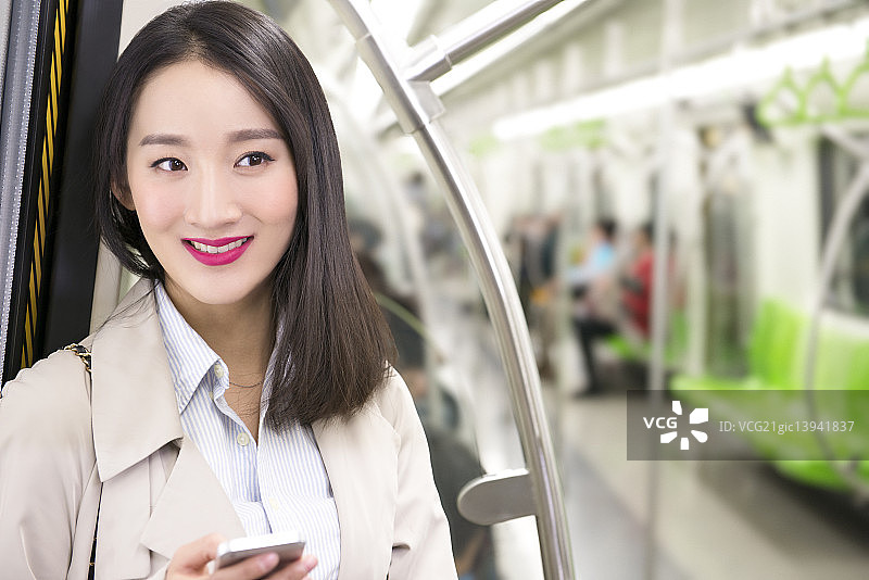 Businesswoman using smart phone in subway图片素材
