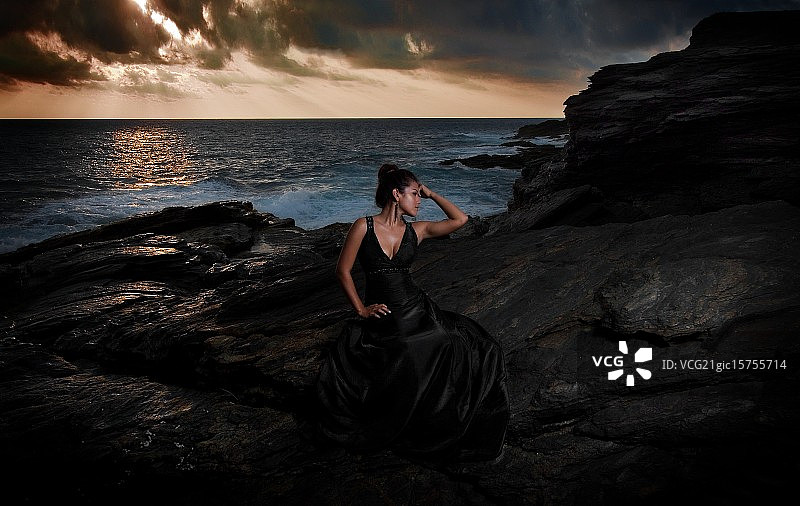 墨西哥瓦哈卡市，坐在岩石上的黑衣女子图片素材