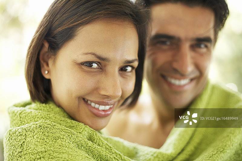 微笑的夫妇裹在毛巾里图片素材