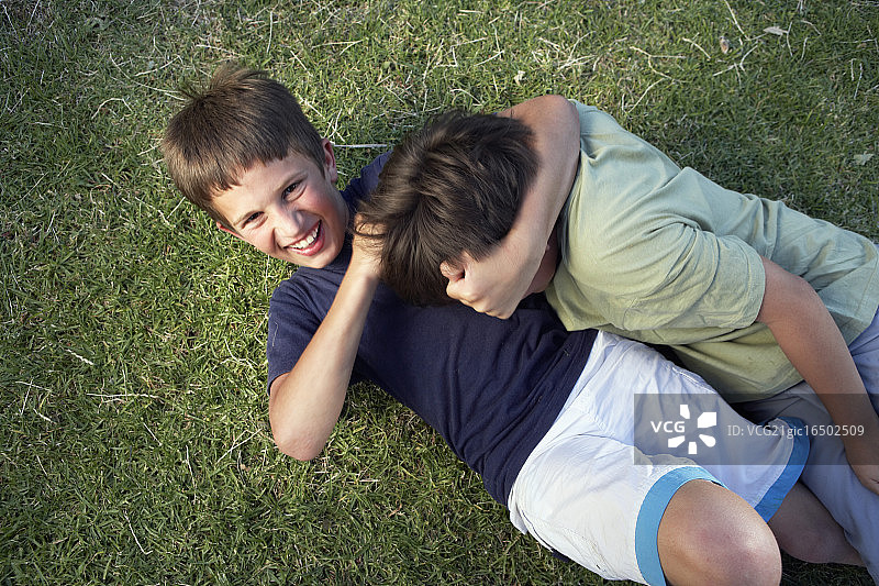 两个男孩在草地上打架图片素材