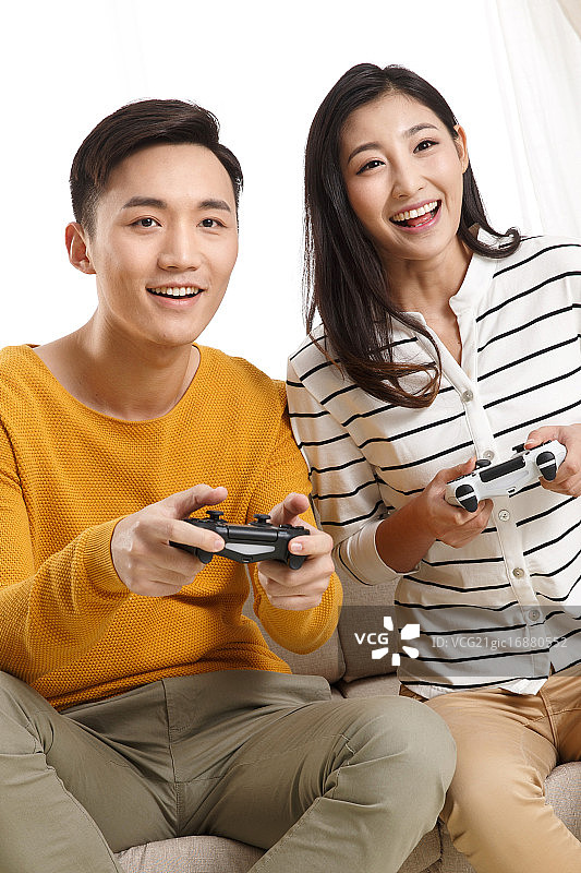 青年情侣坐着沙发上玩游戏图片素材