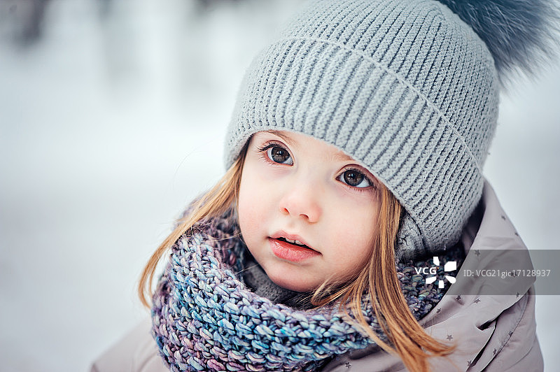 快乐的小女孩在雪地里散步图片素材