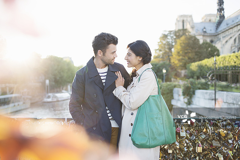 一对情侣站在法国巴黎塞纳河上的艺术桥上图片素材
