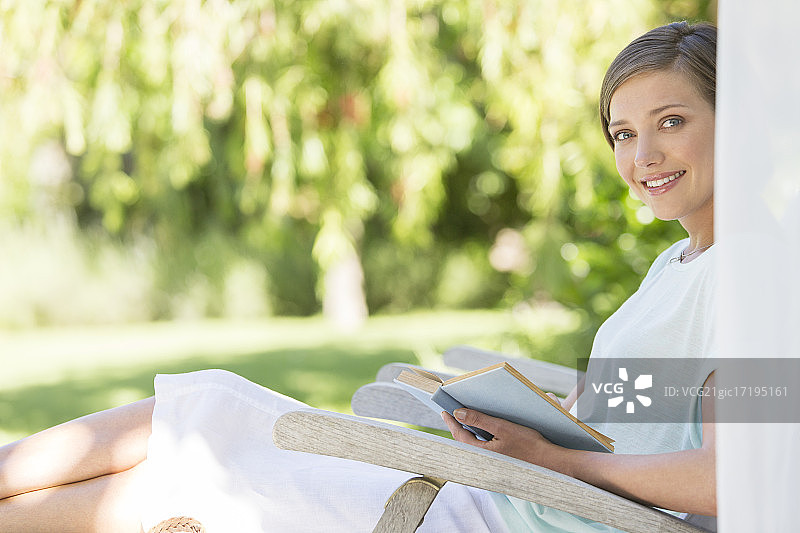 在户外草坪椅上看书的女人图片素材